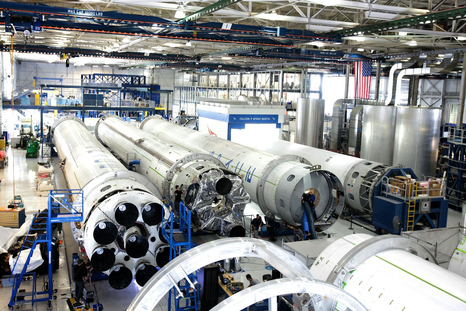 View of a spacecraft assembly line with rockets in a spacious hangar.