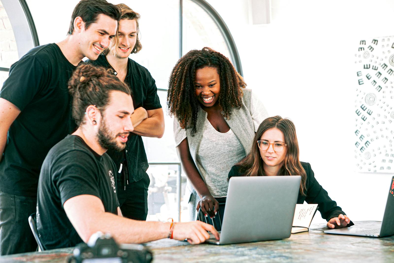 Dynamic team of young adults collaborating on project in bright modern office environment.